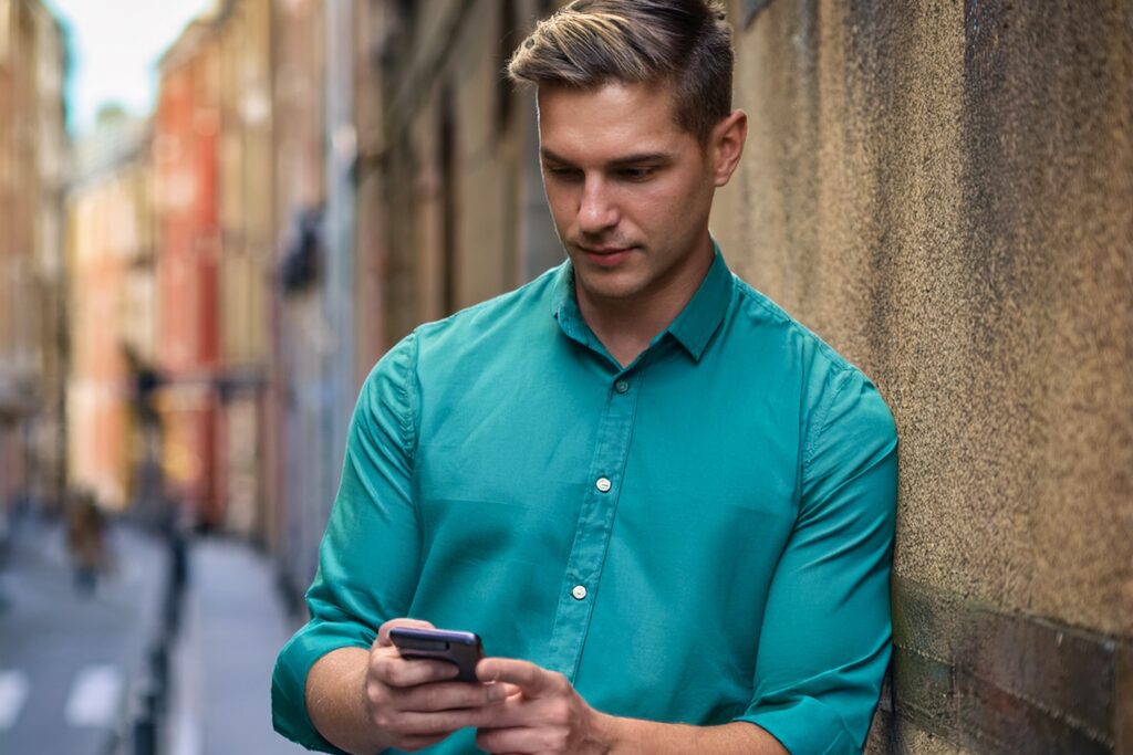 Man looking at his phone on an English street